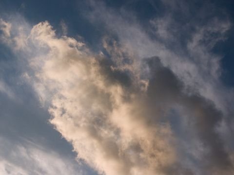 A gold-lit cloud bank crossing a gray sky