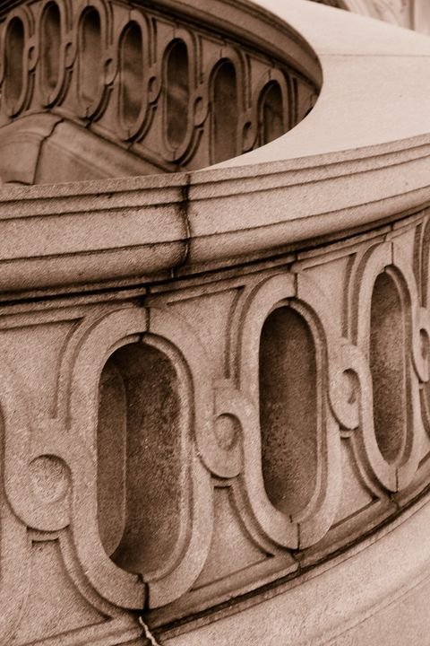 A carved stone balustrade curving through the frame