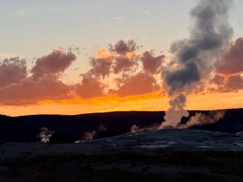 Steam columns silhouetted against the orange dusk