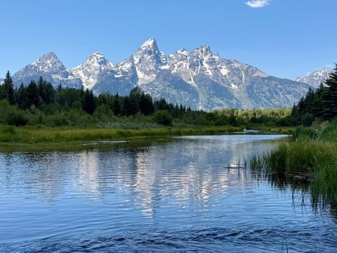 The Tetons mirrored in a still beaver pond at Schwabacher Landing