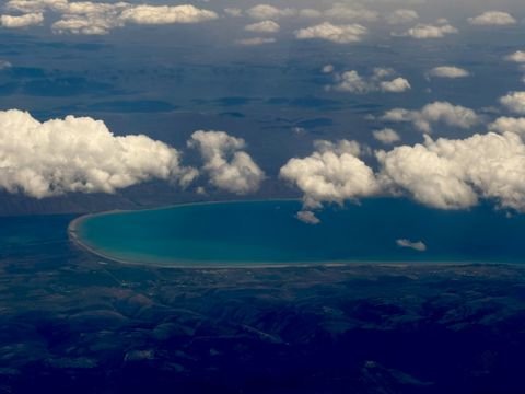 A turquoise lake set in dark mountains, seen from the plane home