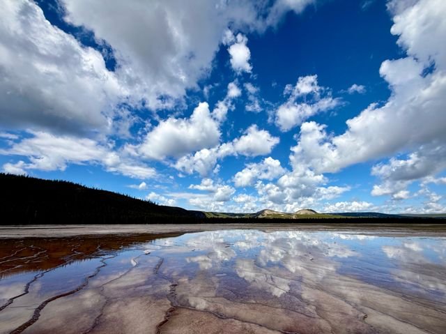 Cumulus reflected in the thin water of a thermal terrace, Yellowstone